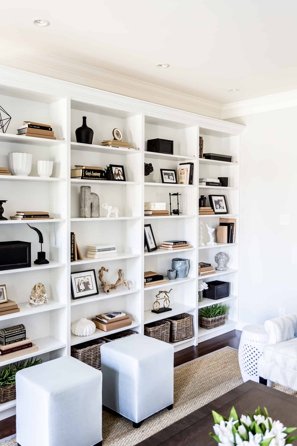 Massive bookcase covering large wall with an assortment of decorations on it