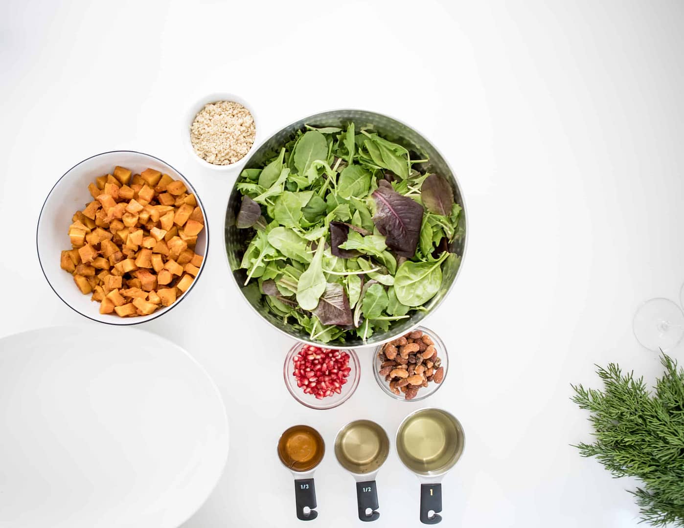 Salad, vegetables and measuring cups on a white table