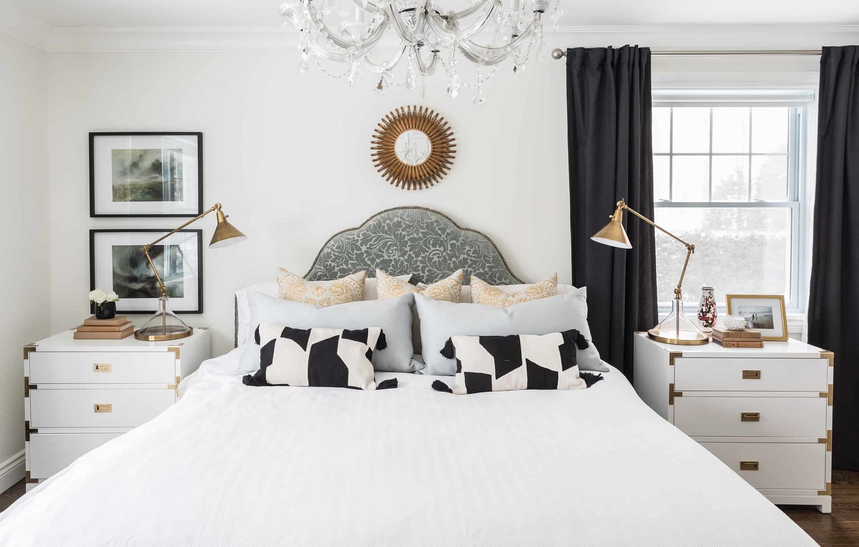 Fancy white chandelier over the bed inside the master bedroom