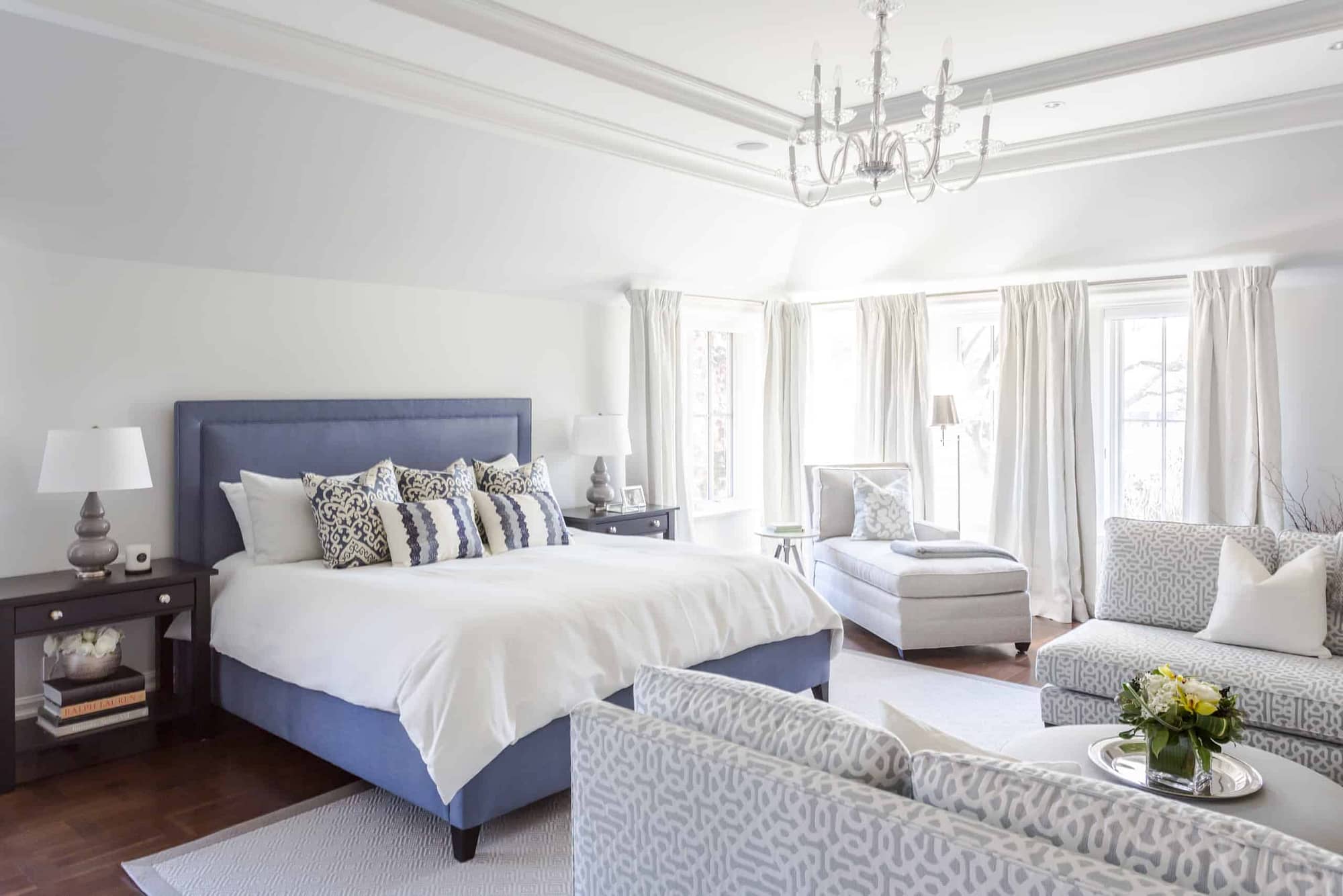 Large blue bed with a white blanket on it inside the master bedroom