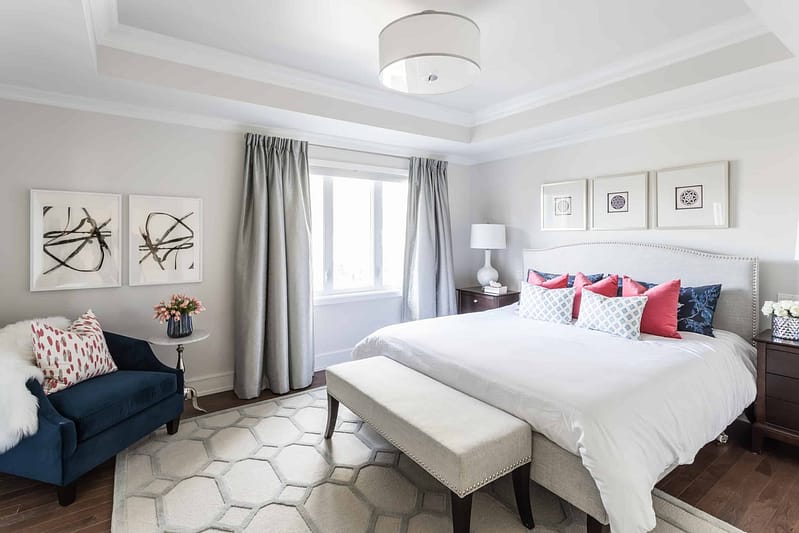 Large white bed with three pictures above it